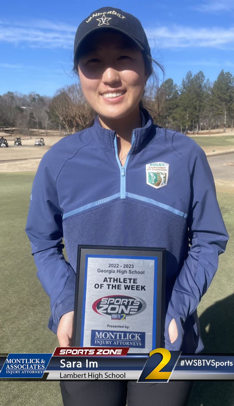 Smiling high school athlete holding Sports Zone Athlete of the Week award