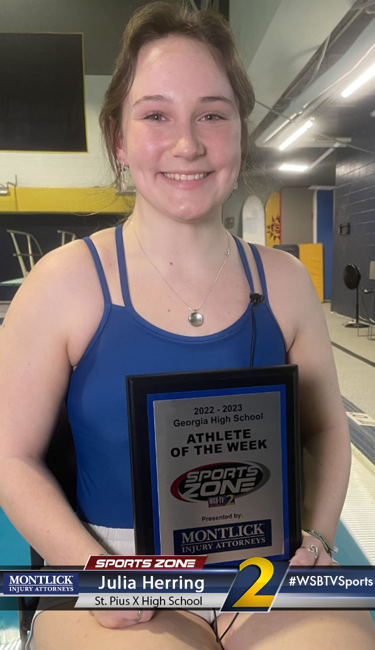 Smiling high school athlete holding Sports Zone Athlete of the Week award