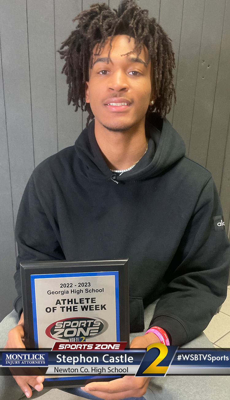 Smiling high school athlete holding Sports Zone Athlete of the Week award