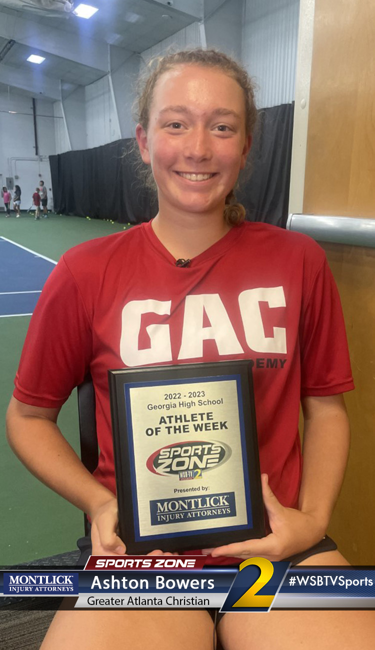 Smiling high school athlete holding Sports Zone Athlete of the Week award