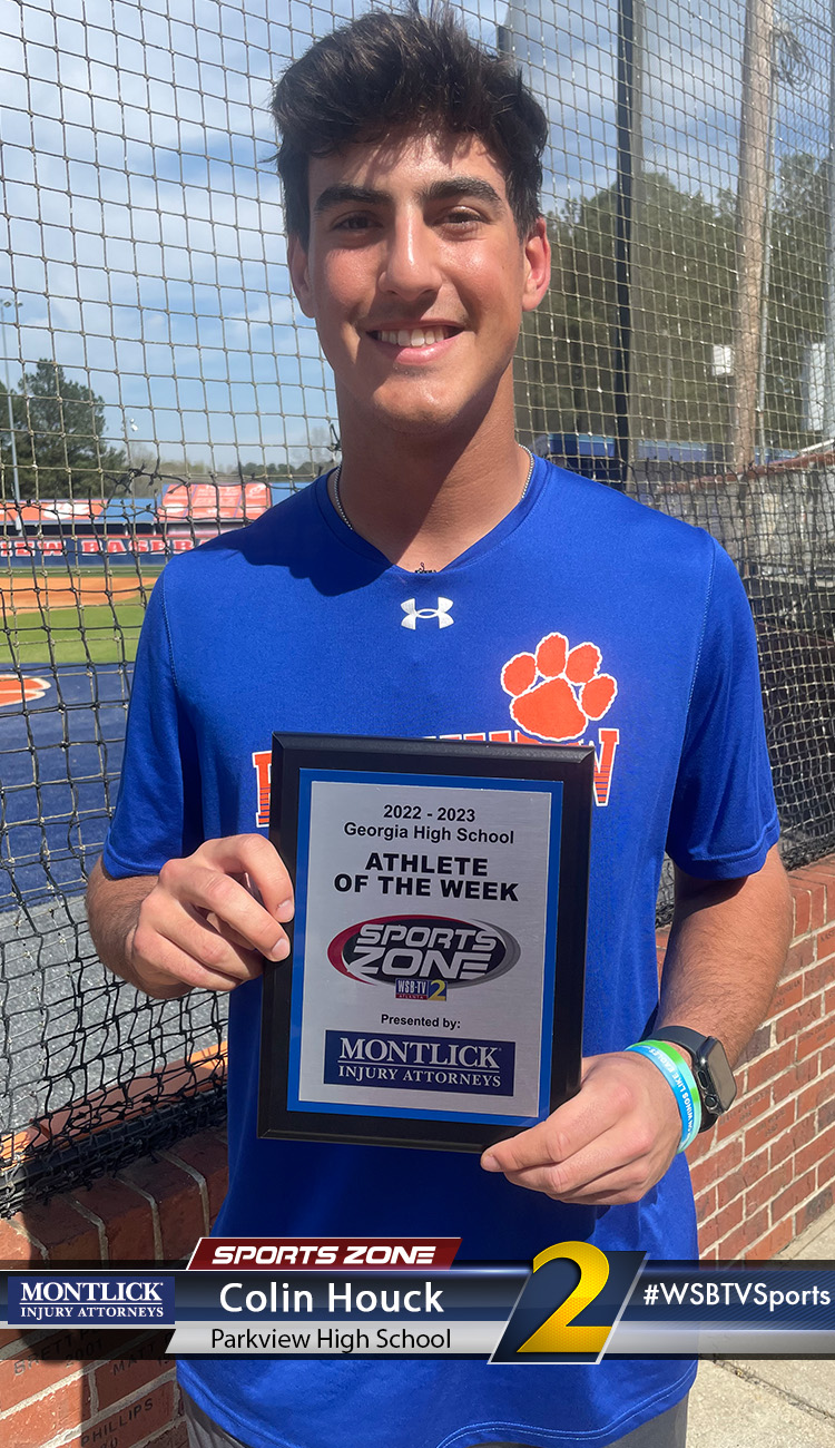 Smiling high school athlete holding Sports Zone Athlete of the Week award