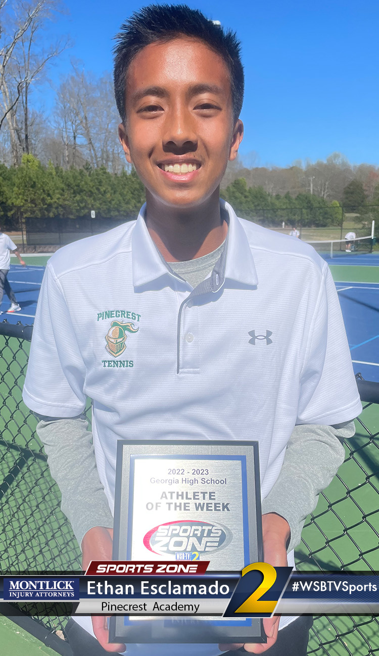 Smiling high school athlete holding Sports Zone Athlete of the Week award