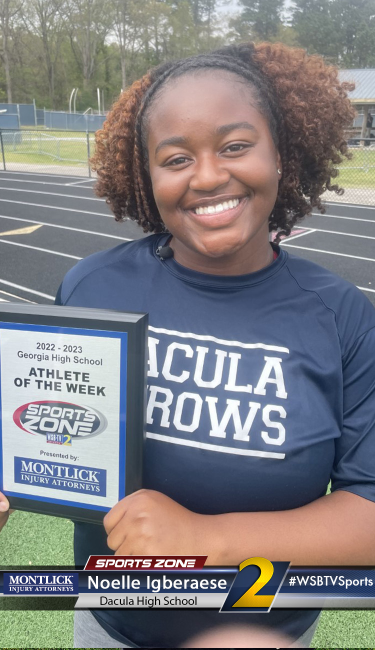 Smiling high school athlete holding Sports Zone Athlete of the Week award