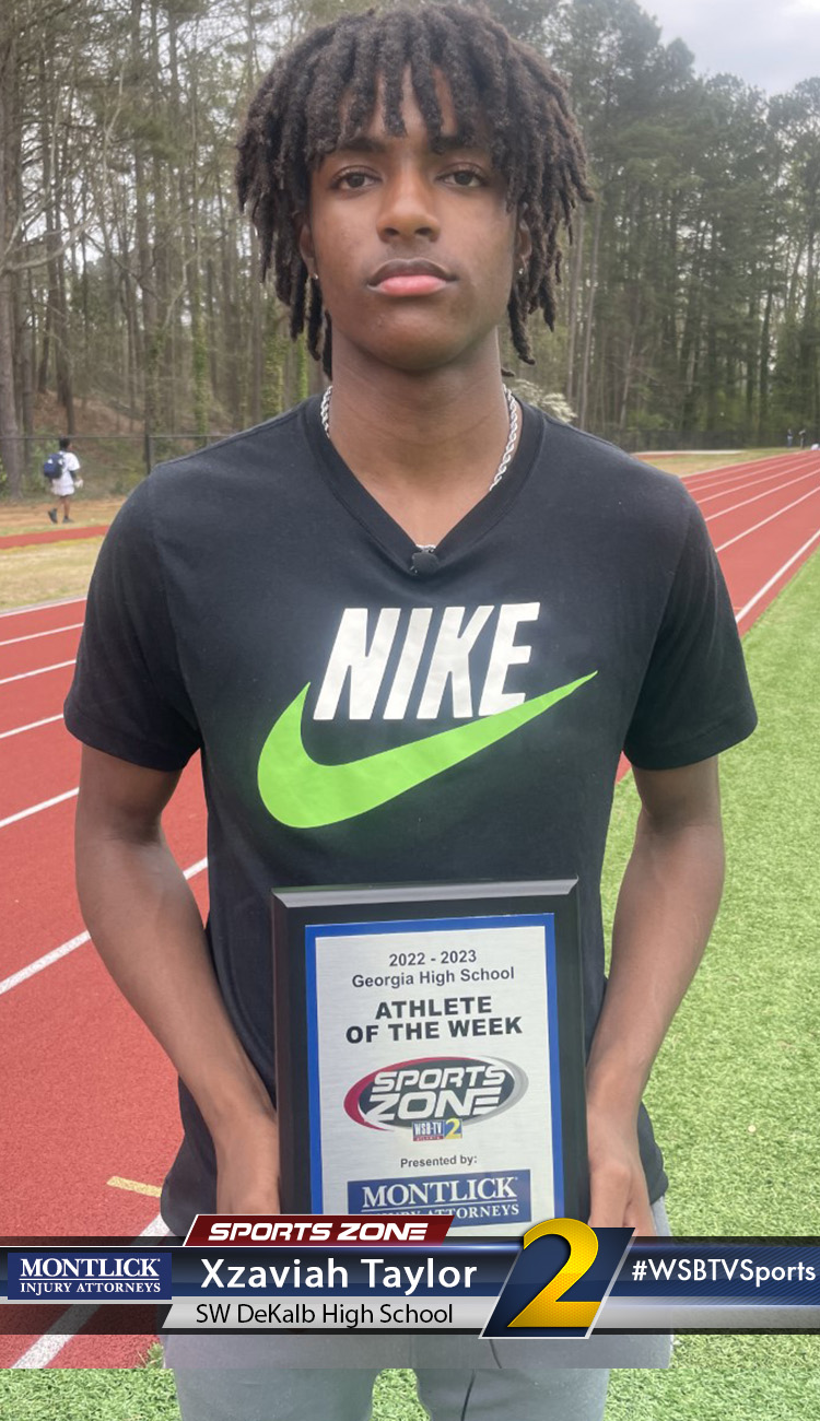 Smiling high school athlete holding Sports Zone Athlete of the Week award