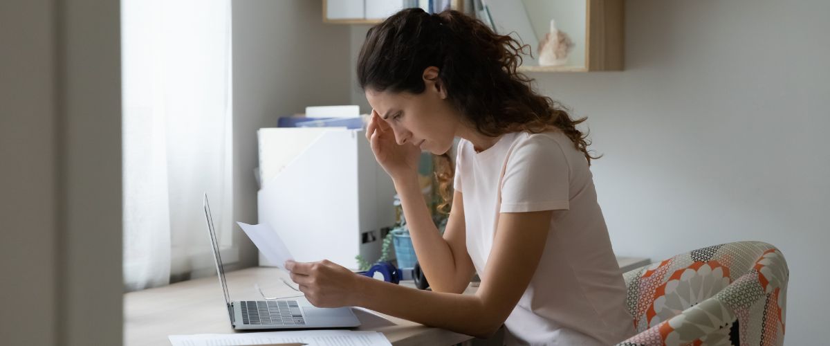 a stressed young woman at her computer looking at a medical bill