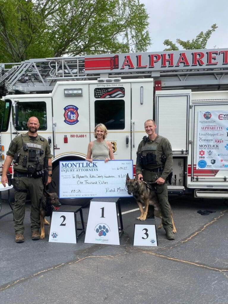 Jenny Harty of Montlick Injury Attorneys awarding check to first responders at Alpharetta Public Safety Foundation