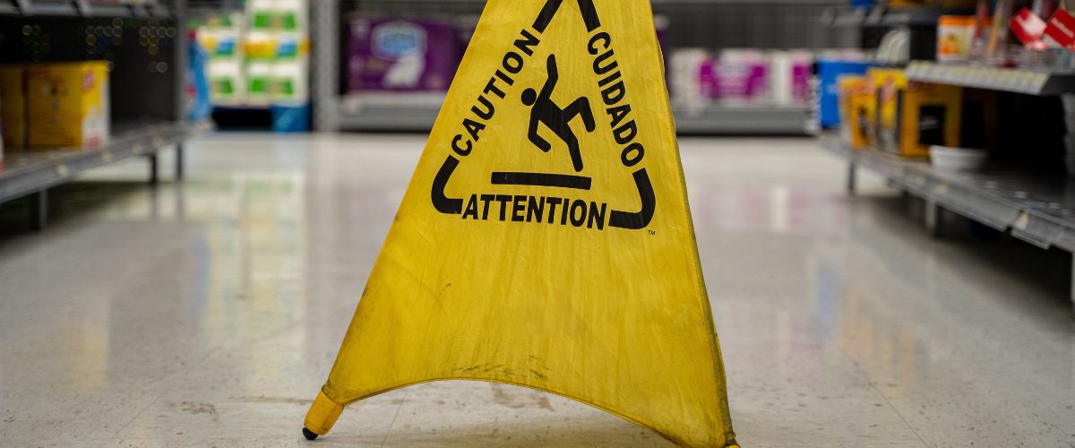 A slip hazard sign on the floor of a supermarket